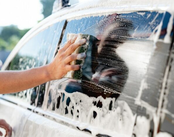 hand-with-sponge-washing-car-window_156881-3794-595x471