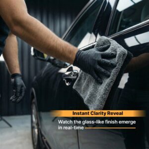 Shiny black car being polished with microfiber cloth for a glass-like finish.