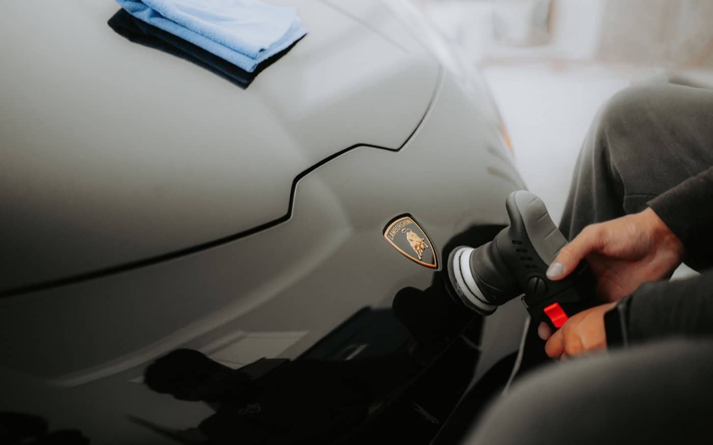 Professional detailer polishing a car before ceramic coating