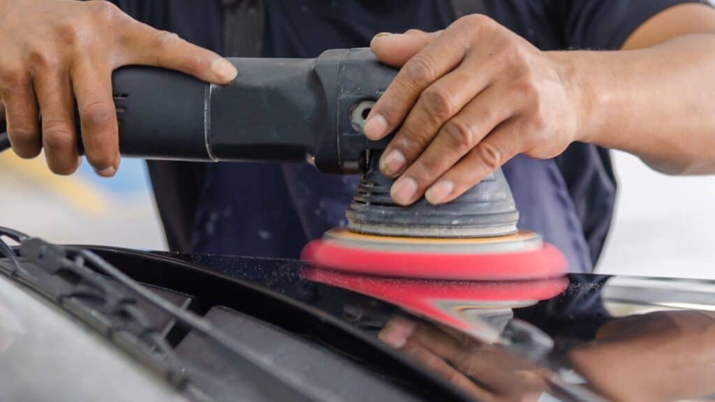 Detailer polishing a car panel before ceramic coating